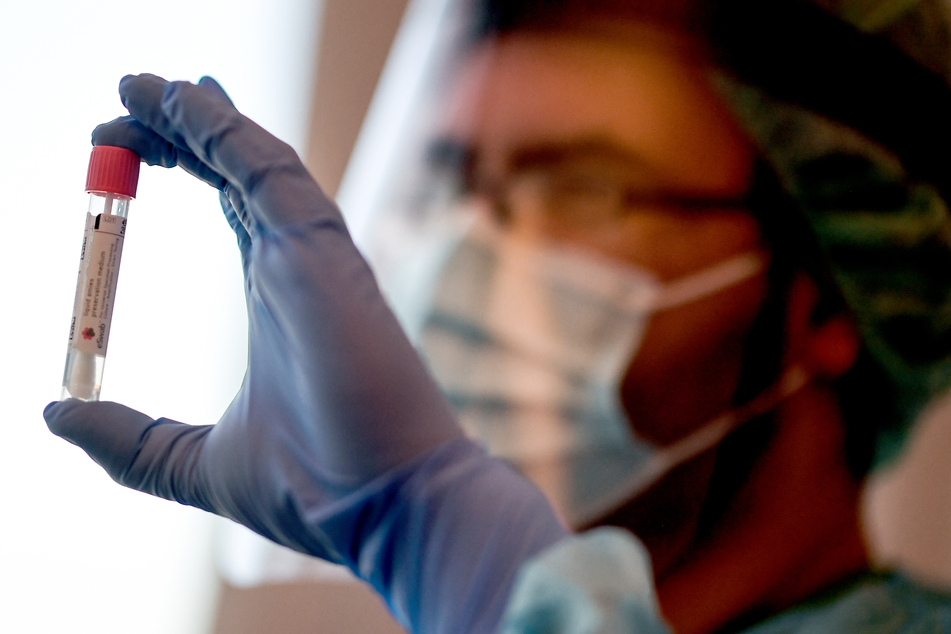Ein Arzt hält in der Corona-Teststelle am Flughafen Schönefeld einen Abstrich für einen Coronavirus-Test.