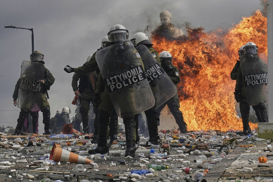 Athen: Polizisten stehen vor den Flammen eines Molotowcocktails vor dem Parlament während der Zusammenstöße mit Demonstranten