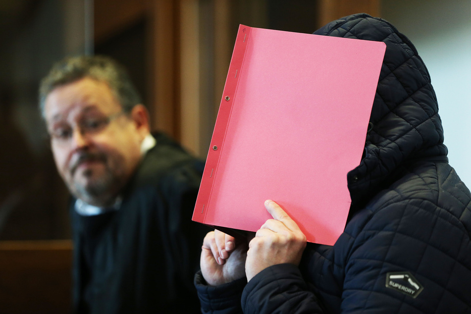 Der Angeklagte (r) im Prozess wegen schweren sexuellen Missbrauchs von Kindern sitzt Gerichtssaal.