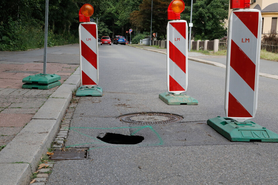 Unwetterschäden: Die Bürgerstraße in Chemnitz wurde durch heftige Regenfälle unterspült. Ein kleines Loch ist auf der Fahrbahn zu sehen.