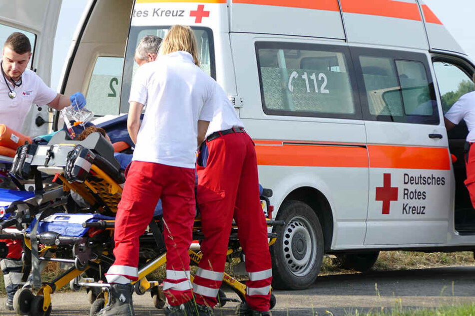 Sanitäter bringen eine verletzte Person in einen Krankenwagen
