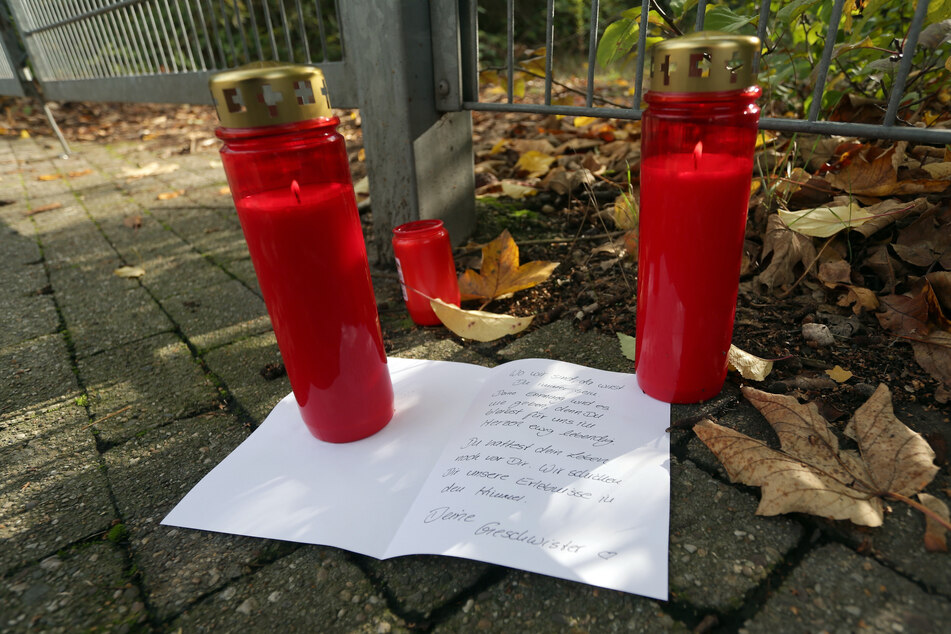 Familienangehörige haben Kerzen und einen Brief vor dem Tor zu dem Gelände, auf dem ein Mädchen tot aufgefunden worden war, abgelegt und aufgestellt.