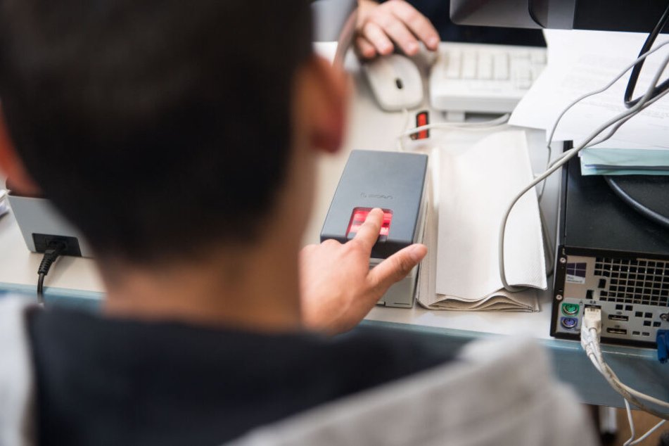 Minderjähriger Flüchtling gibt bei der Registrierung in Deutschland Fingerabdrücke ab.