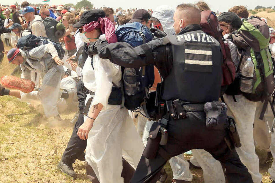 Polizisten versuchen Aktivisten daran zu hindern, den Tagebau Garzweiler zu betreten.