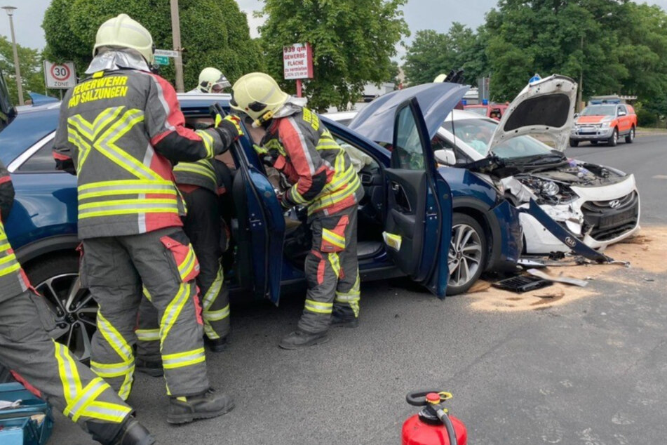 Die Kameraden der Feuerwehr stehen an der Unfallstelle. Beide Autos sind stark beschädigt.