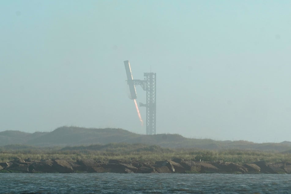 The SpaceX Starship rocket's Super Heavy booster lands as seen from South Padre Island near Brownsville, Texas, on January 16, 2025.