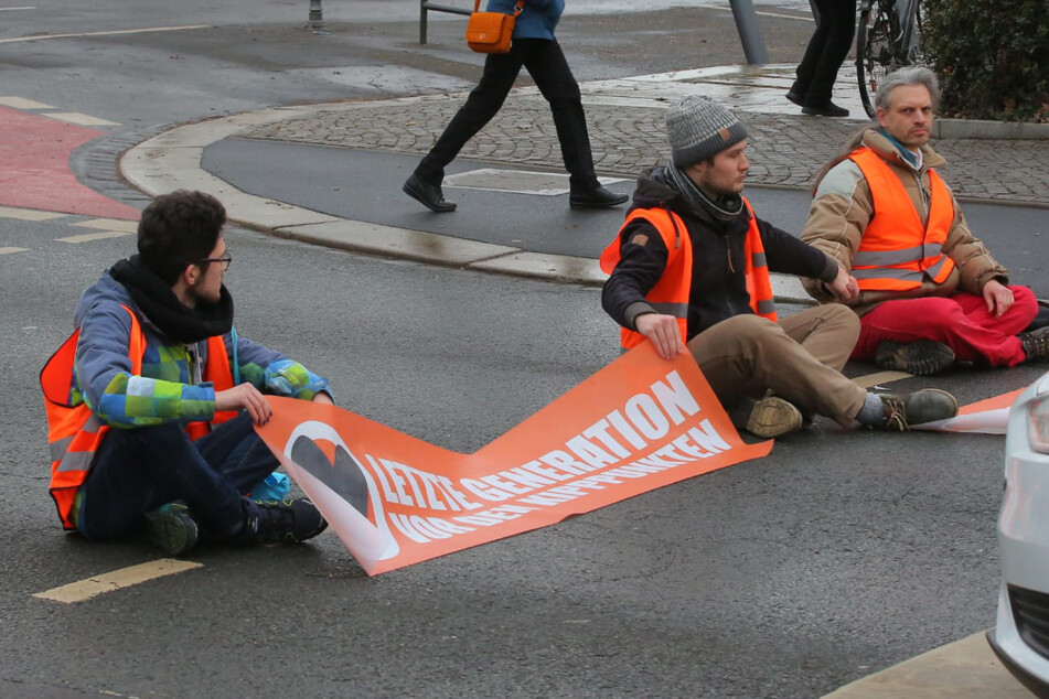 Zur Mittagszeit klebten sich die Aktivisten aneinander fest und blockierten damit stadteinwärts den Verkehr. Ganz rechts: Christian Bläul (41) hat sich an seinen Mitstreiter geklebt.