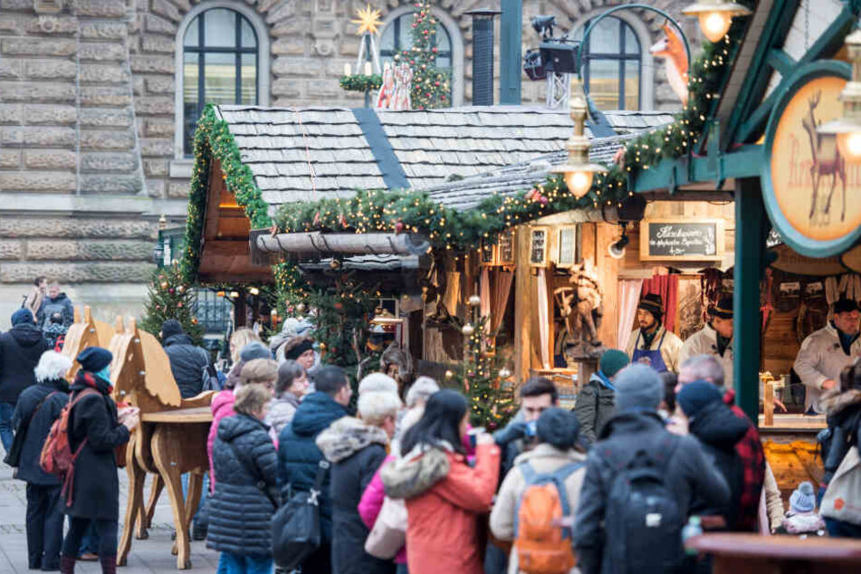 Besucher gehen über den Weihnachtsmarkt auf dem Rathausmarkt.
