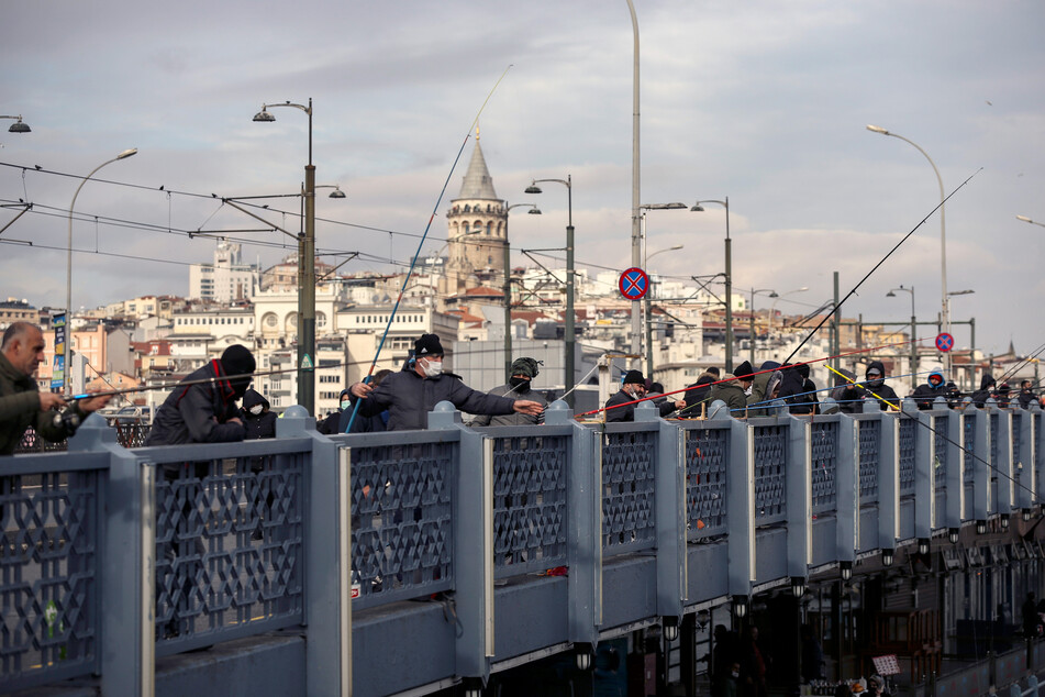 Angler - mal mit und mal ohne Corona-Maske - auf der Galata-Brücke in Istanbul: Die Infektionszahlen in der Türkei steigen immer weiter an.
