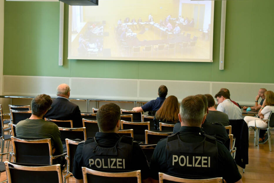 olizisten und Zuhörer verfolgen im Landtag die Videoübertragung der Sitzung des Parlamentarischen Untersuchungsausschusses zur Rocker-Affäre.