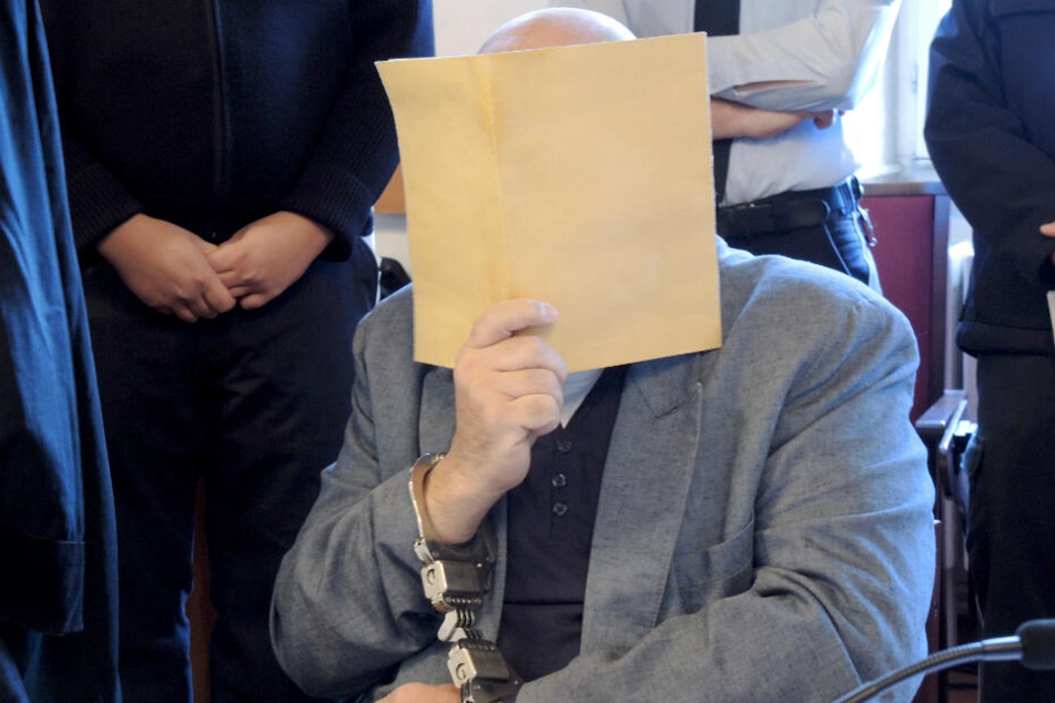 20. Dezember: Der 55-Jährige hält sich einen Aktendeckel vors Gesicht.