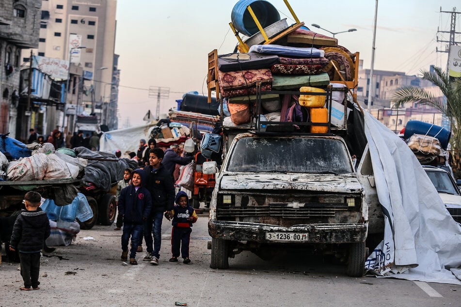 Vertriebene Palästinenser warten entlang der Salah al-Din-Straße in Nuseirat, in der Nähe des blockierten Netzarim-Korridors, um in den nördlichen Teil des Gazastreifens zu gelangen.