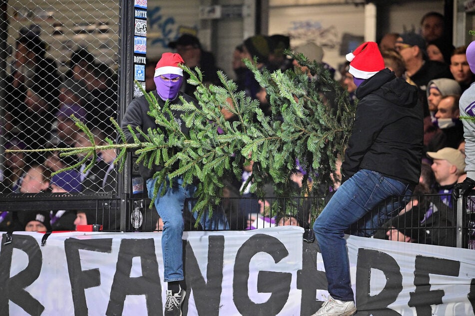 Maskierte Fans des VfL Osnabrück mit Weihnachtsmützen warfen beim Spiel gegen den SC Verl einen Tannenbaum aufs Feld.