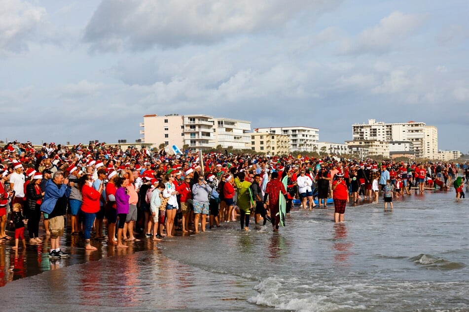 Thousands of people dressed as Santa Claus showed up at Florida's Cocoa Beach to ride waves and raise money for charity.