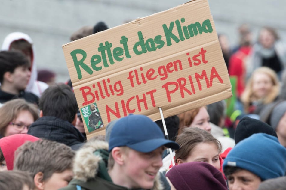 Teilnehmer an der "Fridays for Future" - Klimastreikdemo in Berlin halten Plakate hoch.