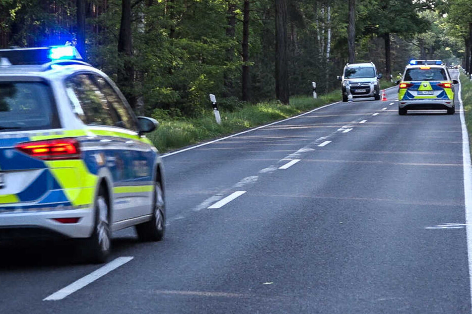 Polizeifahrzeuge stehen auf der Bundesstraße 179 an dem Ort, wo die 81-Jährige in die Gruppe von Fahrradfahrer fuhr.
