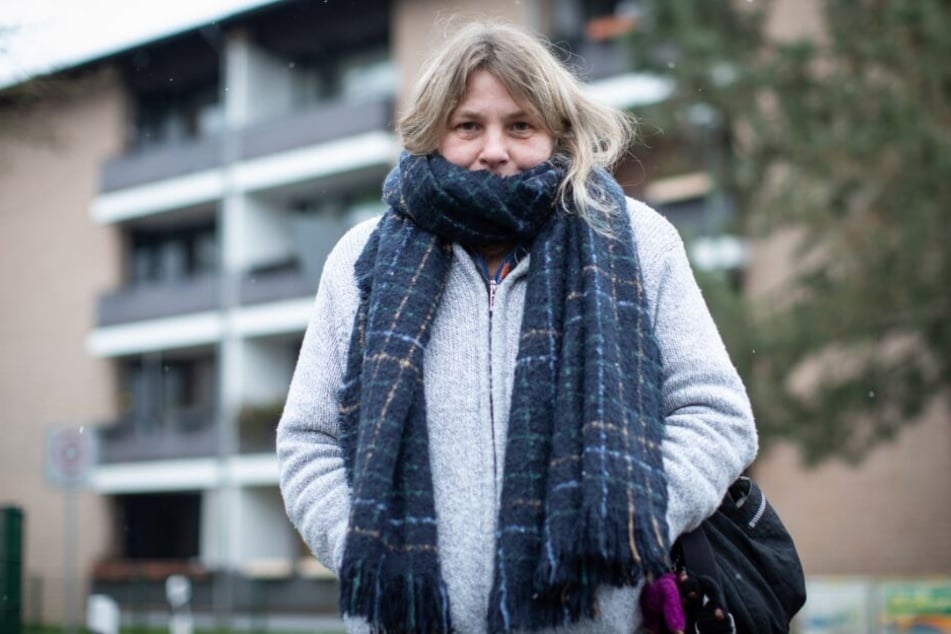 Die Mieterin Daniela Gallien steht mit Schal vor ihrem Wohnhaus.