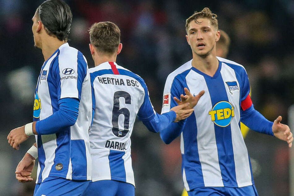 Berlins Niklas Stark (r) und Karim Rekik (l) beglückwünschen Teamkollegen Vladimir Darida (M) nach dessen Treffer gegen Borussia Dortmund.