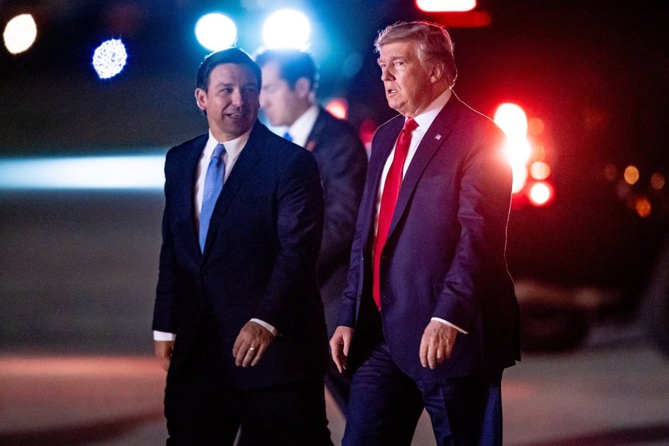 Donald Trump arriving at Palm Beach International Airport, greeted by Florida Governor Ron DeSantis (l.) on November 26, 2019.
