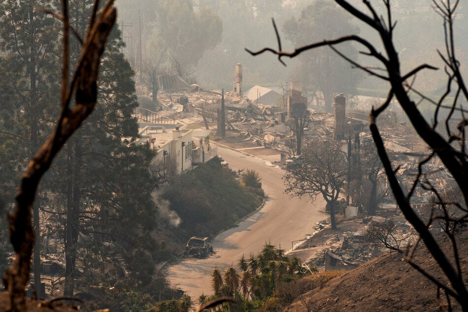 A burnt car stands amidst remains of homes following the Palisades Fire in the Pacific Palisades neighborhood in Los Angeles, California, on January 10, 2025.