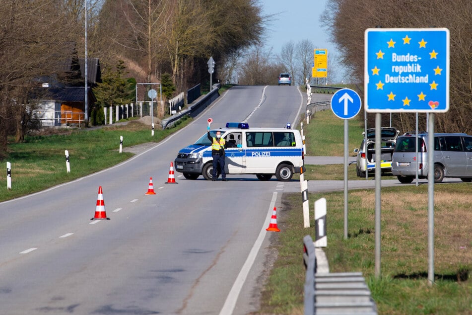 Bayerische Polizisten stehen einer Kontrollstelle an der Grenze zu Österreich.