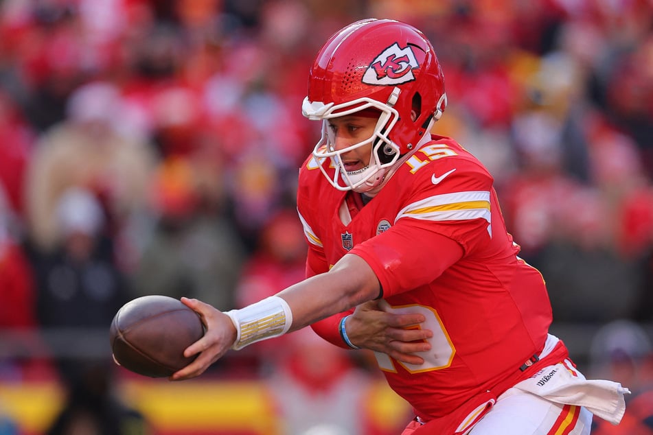 Patrick Mahomes of the Kansas City Chiefs hands off during the third quarter against the Los Angeles Chargers at Arrowhead Stadium on December 14, 2025.