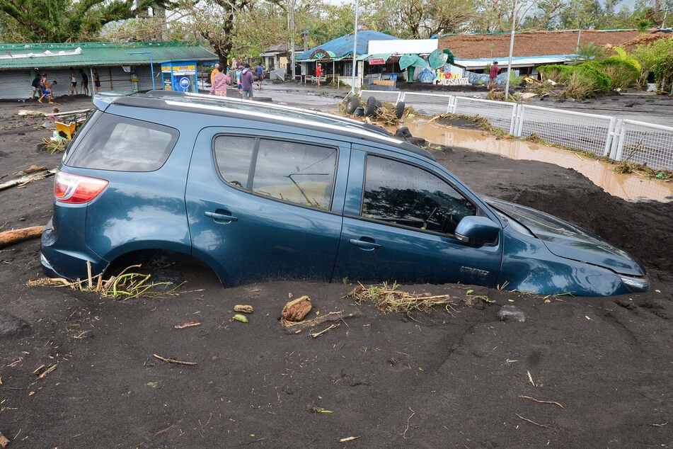 A car is buried in mud after a flood brought by the heavy rains from typhoon Goni in Albay Province, the Philippines.