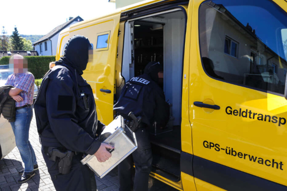 Schwerbewaffnete Polizisten beim Abtransport von Bargeld, dass eine Clan-Familie in einem Wohnhaus gebunkert hatte.