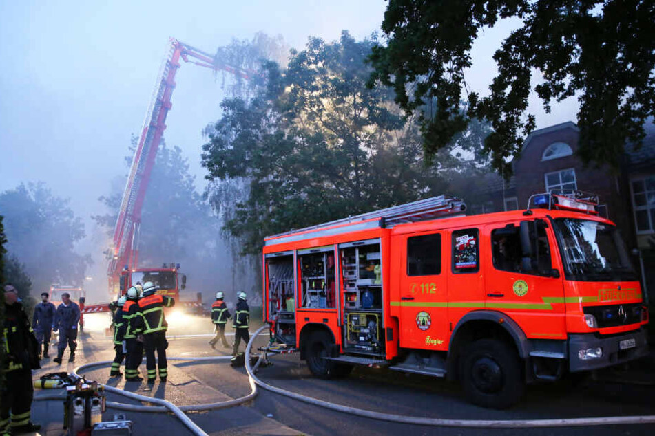Feuerwehrleute löschen eine brennende Seniorenanlage in Hamburg.