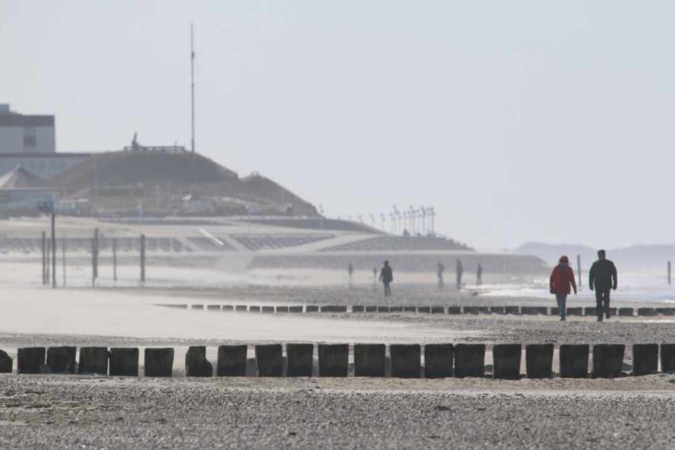Nur vereinzelt gehen Menschen am Strand von Norderney spazieren.