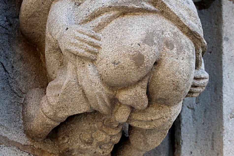 Ein Stein-Männchen, das offenbar Oralverkehr mit sich selbst hat, hängt am Rathausturm.