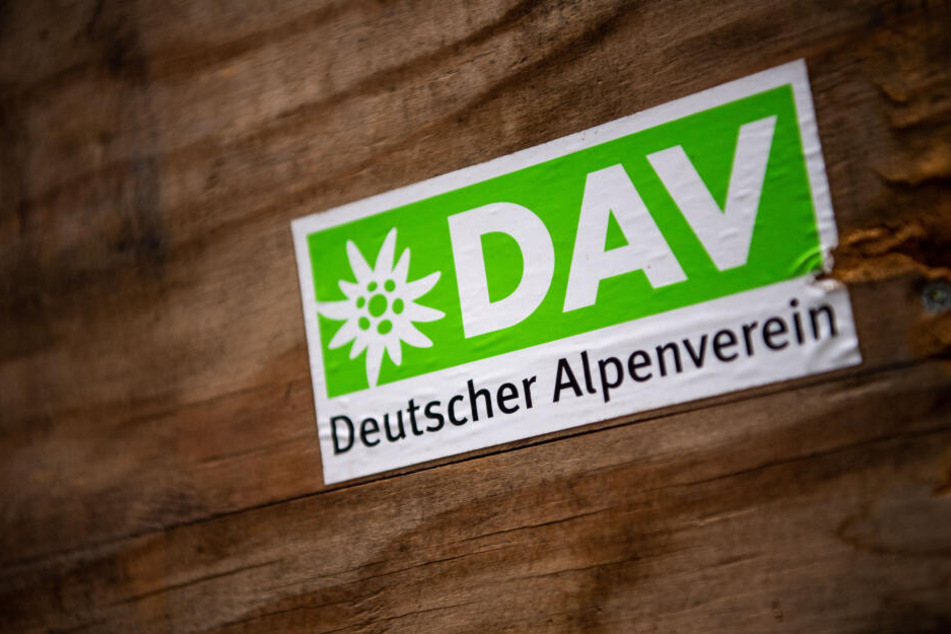 Das Logo des Deutschen Alpenverein (DAV) klebt auf einer Holzbox.