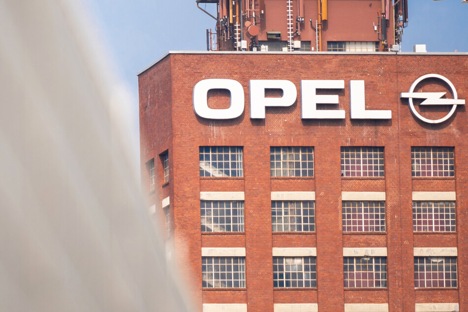 Der historische Opelturm steht hinter einem Zaun auf dem Werksgelände von Opel im südhessischen Rüsselsheim.