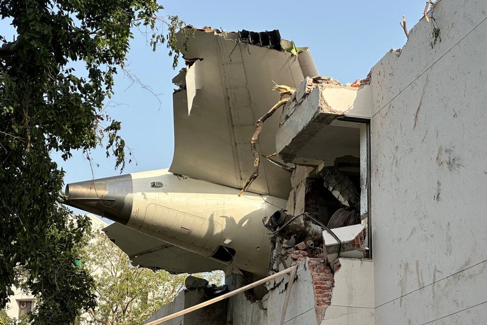 A tail of an Air India Boeing 787 Dreamliner plane that crashed is seen stuck on a building after the accident in Ahmedabad, India, on June 12, 2025.