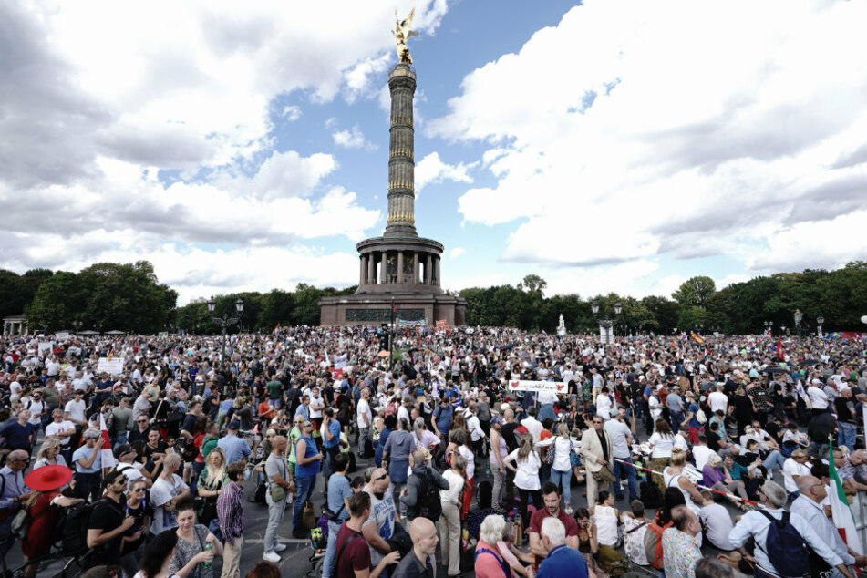 Teilnehmer einer Demonstration gegen die Corona-Maßnahmen stehen auf der Straße des 17. Juni und um die Siegessäule.