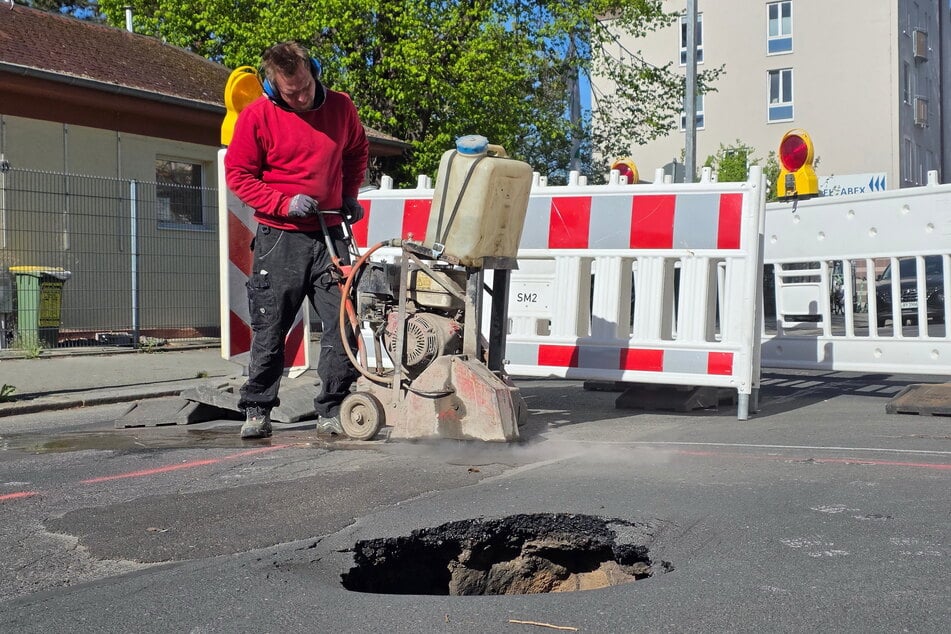 Mitarbeiter des Tiefbau-Unternehmens "Radeck" trennen für eine Freilegung des Erdreichs den Asphalt auf.