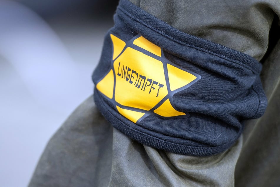 Bei einer Demonstration gegen die Einschränkungen durch die Pandemie-Maßnahmen der Bundesregierung am Brandenburger Tor trägt ein Teilnehmer eine Armbinde mit einem gelben Stern, der an einen Judenstern erinnern soll, mit der Aufschrift "Ungeimpft".