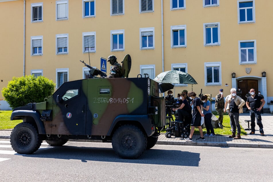 Ein Filmteam des SWR baut eine Einstellung auf, während im Vordergrund ein französisches Militärfahrzeug zu sehen ist.