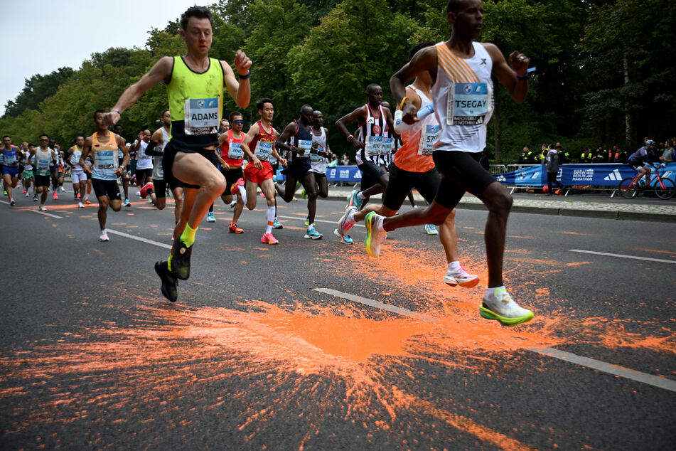 Auf der Marathon-Laufstrecke ist orange Farbe zu sehen.