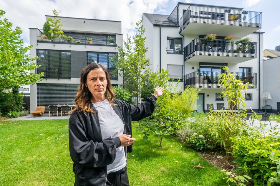 Sindy Hallo (47) zeigt auf den deutlich höheren Nachbarbau (r.), dessen Balkone direkten Einblick auf ihr Grundstück in der Hauboldstraße ermöglichen.