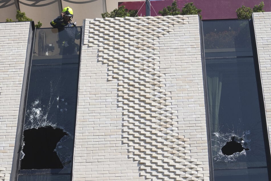 Ein Feuerwehrmann überprüft nach dem Brand des Hotels die zerstörten Fenster.