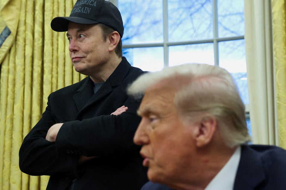 Elon Musk listens to President Donald Trump speak in the Oval Office of the White House.