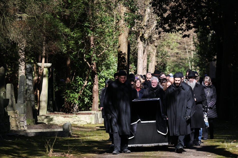 Der Trauerzug geht hinter dem Sarg bei der Trauerfeier für die verstorbene Autorin auf dem jüdischen Friedhof in Hamburg-Ohlsdorf.