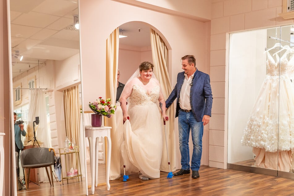 Uwe Herrmann hält den Garderobenvorhang auf - Maria erscheint überglücklich in einem Brautkleid.