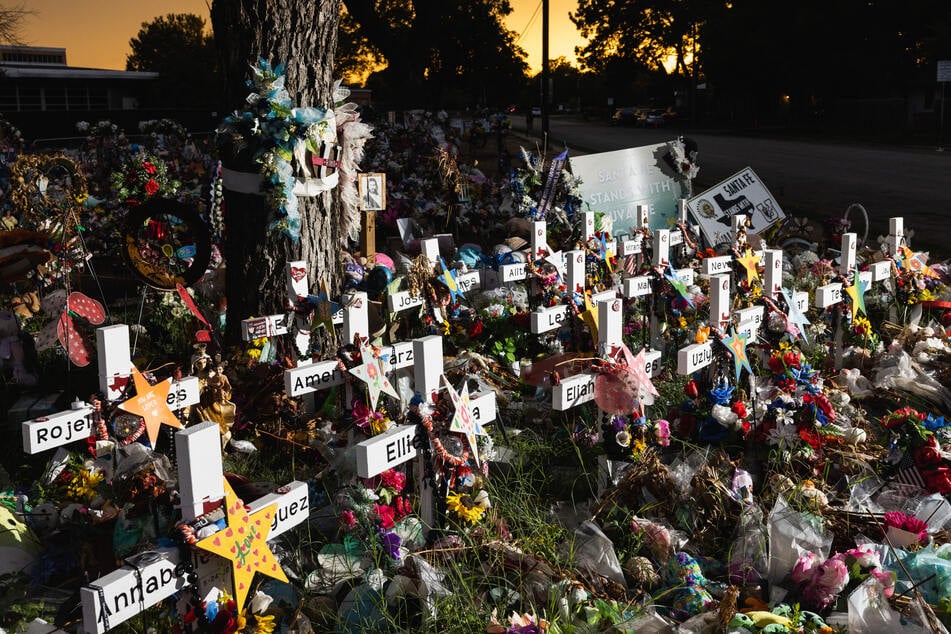 The sun sets behind the memorial for the victims of the massacre at Robb Elementary School on August 24, 2022 in Uvalde, Texas.