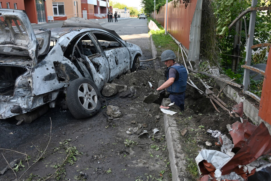 Deminers at the site of a reported cluster munition attack in a residential area in northern Kharkiv, Ukraine, last August.