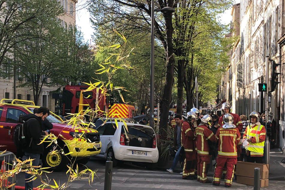 Feuerwehrleute versammeln sich nach dem Einsturz des Hauses im Stadtzentrum von Marseille zum Einsatz.