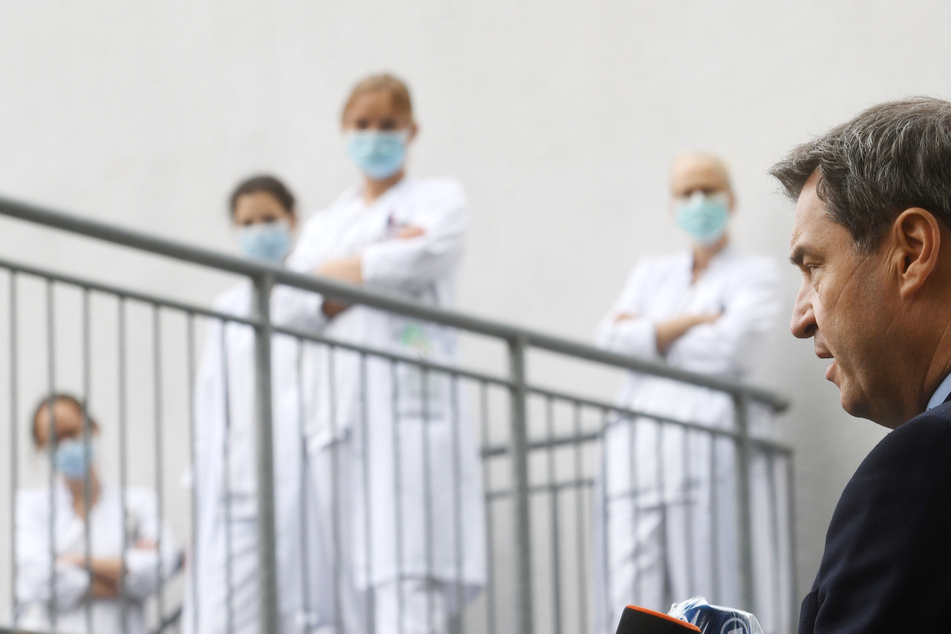 Klinikpersonal verfolgt die Äußerungen von Markus Söder (CSU,r), Ministerpräsident von Bayern, nach einem Besuch der Intensivstation in der München Klinik Schwabing. Ministerpräsident Söder und Oberbürgermeister Reiter hatten die Covid-19-Intensivstation in Haus 3 besucht.