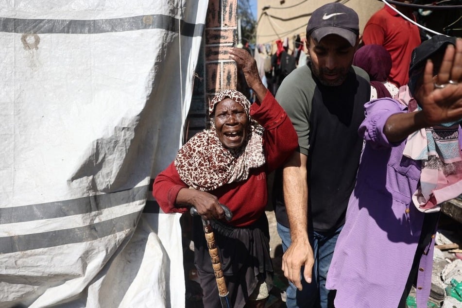 Palestinians react after an Israeli strike hit the Rafida school housing displaced people in Deir al-Balah in the central Gaza Strip on October 10, 2024.