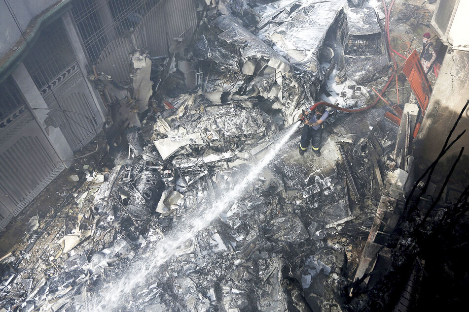 Ein Feuerwehrmann versucht, das Feuer an der Absturzstelle zu löschen.